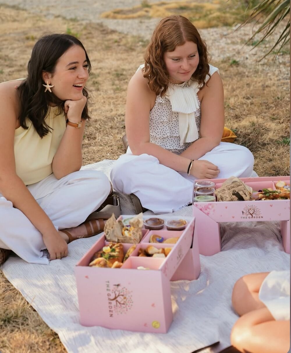 Deux amies en pique-nique avec les box brunch roses The Garden ouvertes