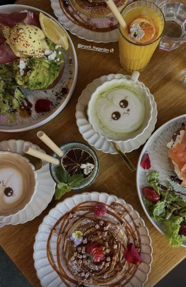 Table de brunch vue du dessus avec latte matcha kawaii, pancakes et tartines